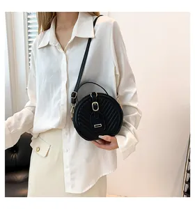 Elegant black round crossbody bag for women featuring quilted pattern and gold buckle
