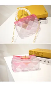 Detail view of mini pink gradient jelly bag with pearl handle and gold chain strap.