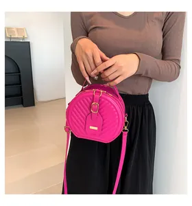 Fashionable pink quilted round crossbody bag shown on a model for scale and daily style
