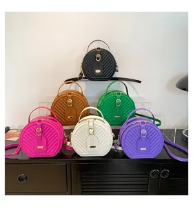 Variety of colorful chevron quilted round crossbody bags displayed on a black cabinet.