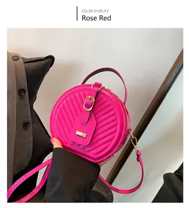 Detailed close-up of rose red round crossbody bag with quilted pattern and gold buckle