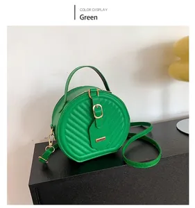 Stylish green round crossbody bag with diagonal quilted pattern and gold buckle
