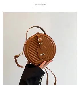 Close-up detail of a stylish brown round quilted crossbody bag with a golden buckle