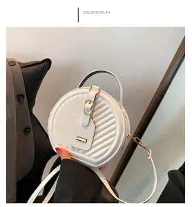Close-up of white round crossbody bag with quilted pattern and buckle detail