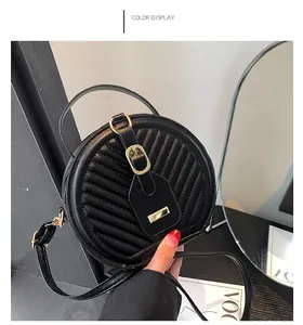 Detailed close-up of a stylish black quilted round crossbody bag with gold buckle.