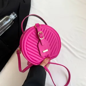 Stylish fuchsia quilted round crossbody handbag with elegant gold-tone buckle detail