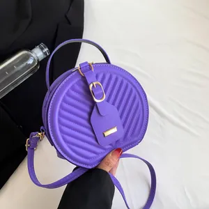 Fashionable purple quilted round crossbody bag with gold buckle and adjustable strap