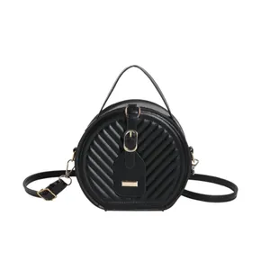 Fashionable black quilted round crossbody bag with top handle and adjustable strap
