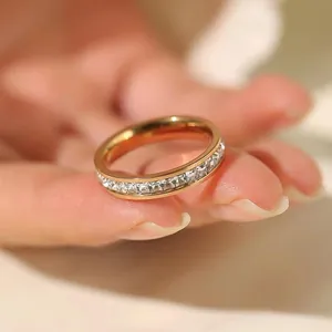 Close-up of a rose gold eternity ring set with square clear stones on a hand