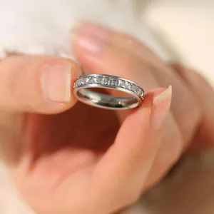 Detailed view of a silver stainless steel ring with channel-set square sparkling crystals