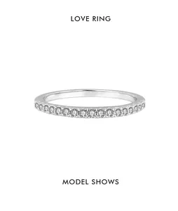 Close-up of minimalist S925 sterling silver ring with a row of sparkling moissanite stones.