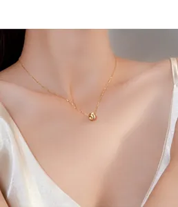 Macro view of a gold-plated brushed bead pendant necklace on a model's collarbone