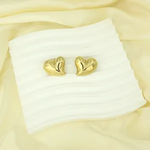 Elegant 18k gold-plated heart-shaped stainless steel stud earrings on wavy display plate