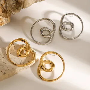 Macro view of minimalist gold and silver spiral hollow stainless steel stud earrings