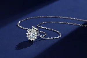 Detailed view of moissanite sunburst pendant with sparkling halo on silver chain