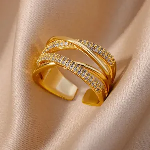 Bague croisée multicouche dorée avec zircons étincelants sur fond de satin élégant
