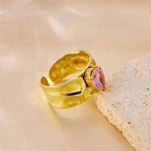 Detail of pink heart zircon on 18k gold plated hammered stainless steel open ring.