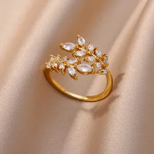 Gros plan d'une bague branche d'olivier en or avec zircons sur soie champagne