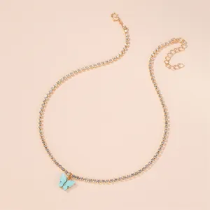 Macro view of gold-tone rhinestone choker necklace with light blue butterfly pendant