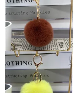 Close-up of 8cm faux rabbit fur pom pom keychains in brown and yellow