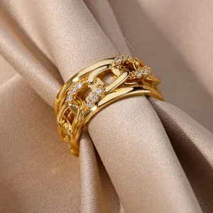 Gros plan d'une bague à nœuds multicouches dorée ornée de zircons étincelants.