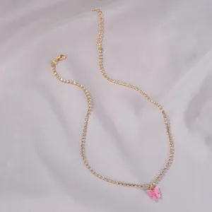 Close-up view of elegant pink butterfly pendant on gold rhinestone chain necklace
