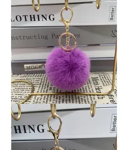 Soft purple faux fur pom pom keychain with gold-toned metal lobster clasp detail