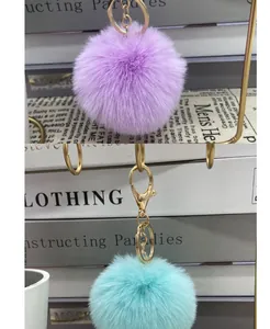 Soft 8cm faux rabbit fur pom pom keychains in purple and light blue color options.