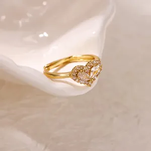 Gros plan d'une bague coeur plaquée or avec pierres en zircon et anneau réglable.