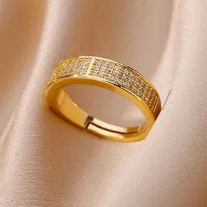Bague ouverte géométrique dorée élégante avec oxydes de zirconium sur fond en satin