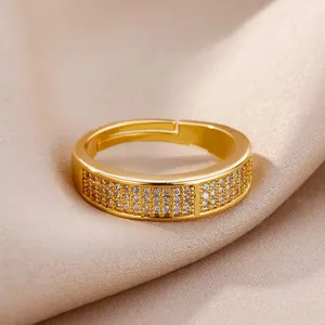 Gros plan détaillé d'une bague géométrique dorée sertie de zircons brillants.