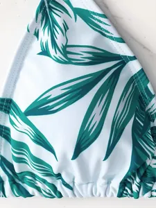 Dettaglio macro della stampa tropicale con foglie di palma verdi su tessuto bikini bianco