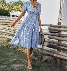 Detail of a blue and white striped V-neck summer dress with puff sleeves and tassels.