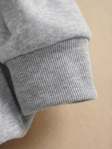 Detailed close-up showing the grey ribbed cuff of a soft fleece-lined sweatshirt