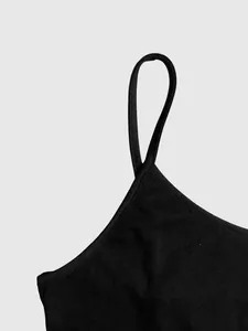 Macro detail view showing the slim shoulder strap and fine stitching of a black dress