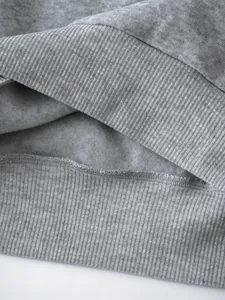 Close-up detail of grey fleece sweatshirt showing ribbed hem and soft interior lining