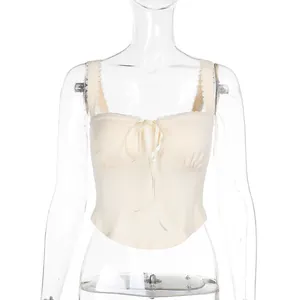 Elegant cream camisole top featuring delicate lace trim and front ribbon bow detail