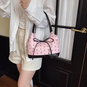 Stylish pink jacquard underarm bag with black bow detail and shoulder straps for women