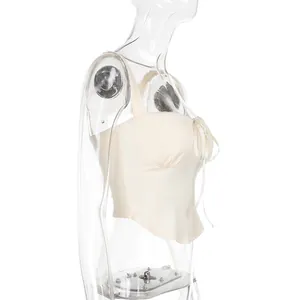 Side view of cream slim-fit camisole top with lace trim and front bow detail