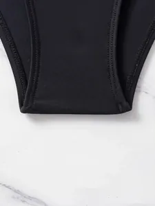 Primo piano dettagliato del tessuto di un costume da bagno nero con cuciture rinforzate.