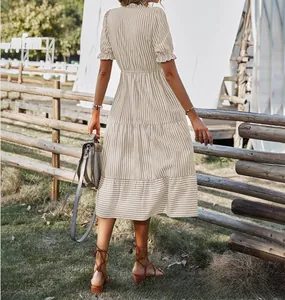 Back view of a striped short sleeve midi dress with elastic waist in an outdoor setting