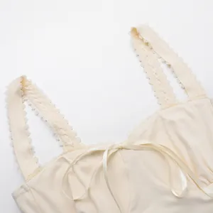 Close-up detail of cream lace trim camisole top featuring a delicate ribbon bow accent
