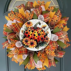 Autumn Thanksgiving wreath featuring pumpkin centerpiece, sunflowers, and mesh ribbons.
