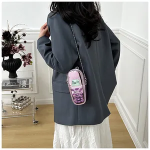 Mini pink retro cell phone shaped crossbody bag styled with a grey blazer