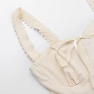 Detailed macro view of cream lace-trimmed camisole with elegant silk ribbon bow detail