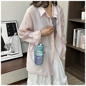 Mini retro mobile phone shaped crossbody bag styled with a pink shirt and white skirt