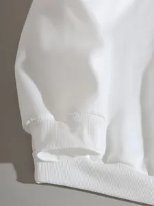 Close-up detail of the ribbed elastic cuff and hem on a white fleece-lined loose sweatshirt