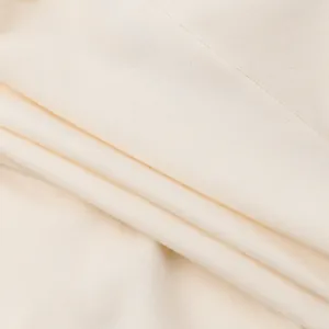 Close-up of the soft cream fabric texture of the slim fit lace camisole top for women.