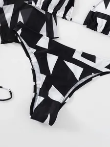 Vista dettagliata della stampa geometrica bianca e nera sullo slip bikini a vita alta
