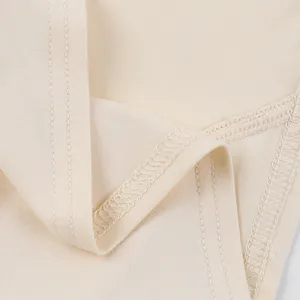 Close-up of beige camisole fabric showing high-quality stitching and smooth texture.
